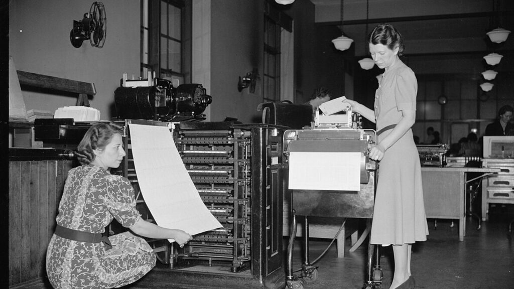 Two women operate a census tabulating machine in 1939 to process data for the 1940 census