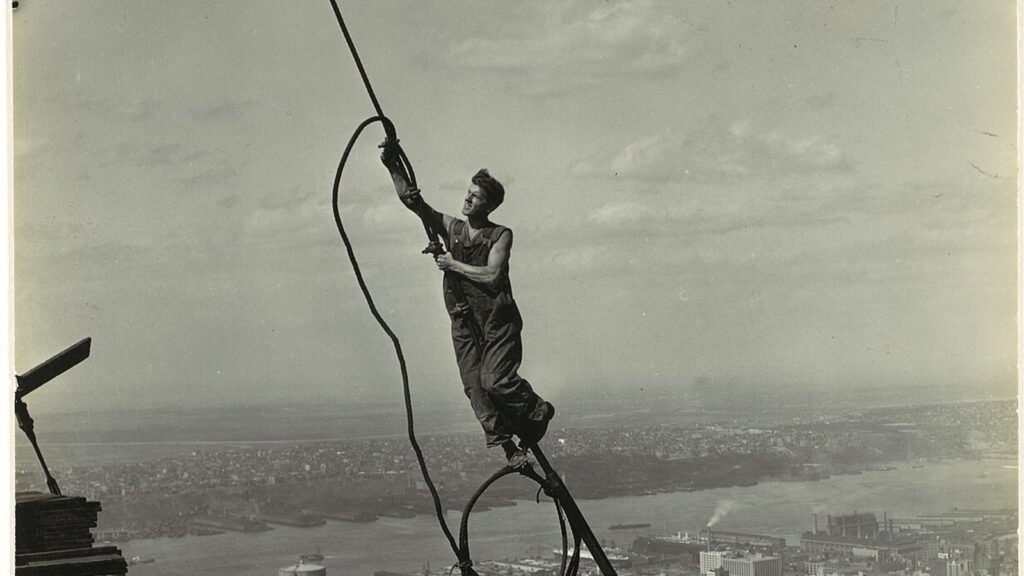 Lewis Hine photo of a construction worker on a cable high above New York during the building of the Empire State Building